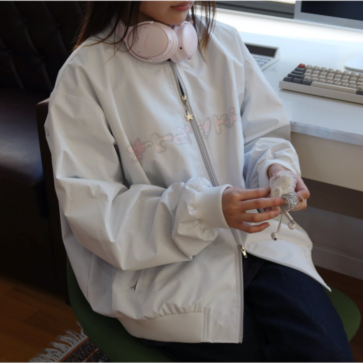 Official seated lifestyle view of the Stray Kids 6th Fan Meeting bomber jacket.