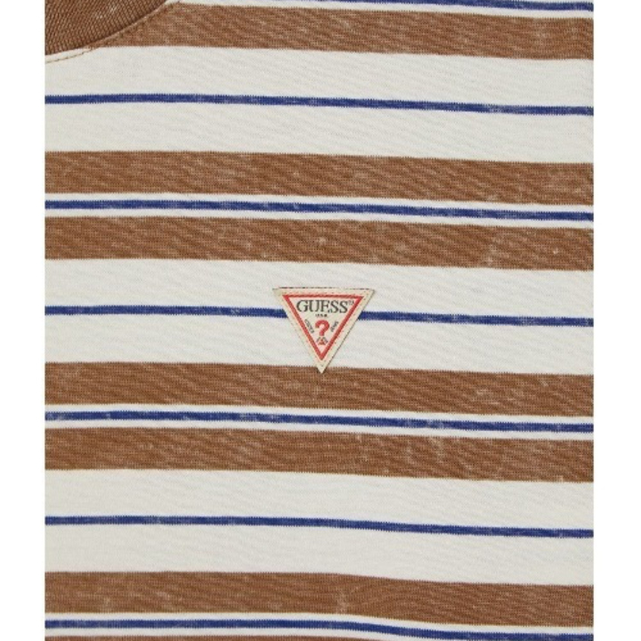 Close-up of the GUESS triangle logo on the Hyunjin striped shirt
