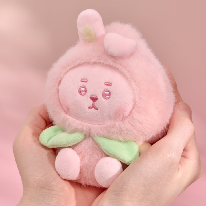 BT21 Peach Holic COOKY plush keyring held in two hands on a pink background