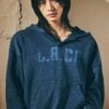 Hyunjin wearing the dark blue GUESS LA-CA hoodie